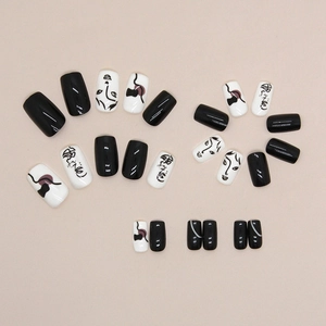 Minimalist black and white press-on nails with abstract face art and glossy finish
