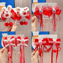 Close-up of red Chinese New Year hair clips with tassels and Hello Kitty design