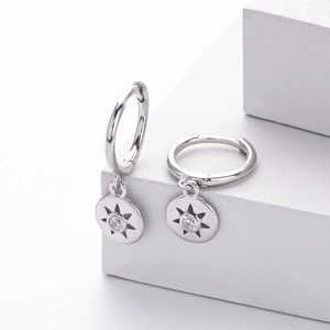 Detail of 925 sterling silver star hoop earrings with zircon on geometric backdrop