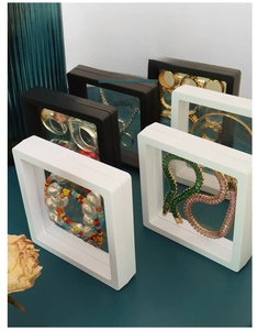 Close-up of black and white floating jewelry boxes with PE film holding necklaces and rings