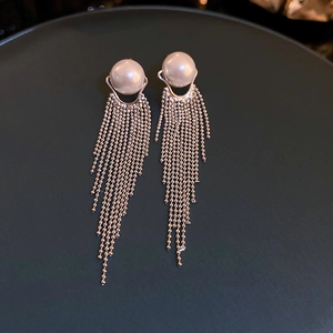 Detailed close-up of elegant long tassel earrings with a large pearl and gold chains