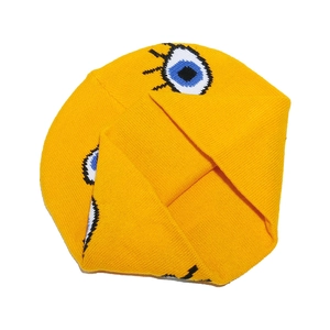 Detailed close-up of bright yellow knit beanie with blue cartoon eye jacquard pattern
