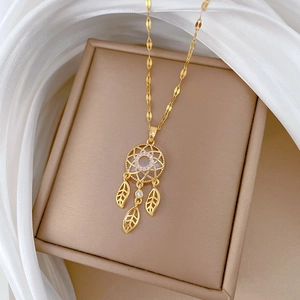 Detail of dreamcatcher pendant necklace with feathers and stones on a jewelry box