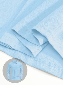 Detail of light blue linen fabric texture and chest pocket on men's long sleeve shirt