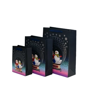 Three sizes of Christmas gift bags with snowman and Santa designs on deep blue paper