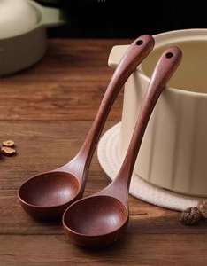 Detail of handcrafted ebony wood soup ladle with natural grain and a hanging hole