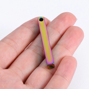 Polished rainbow stainless steel bar pendant held in hand for scale and color