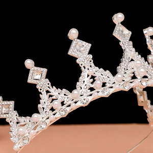 Close-up of silver bridal tiara with white pearls and sparkling crystal leaves