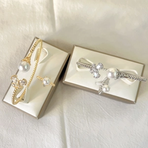 Detail of gold and silver butterfly pearl bangle set with zircon ring in luxury gift box