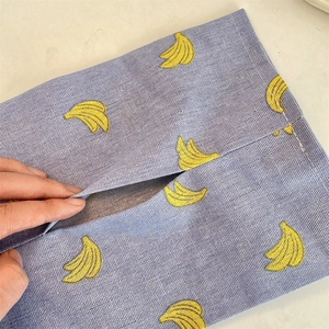 Macro shot of blue cotton linen tissue bag featuring banana pattern and opening detail