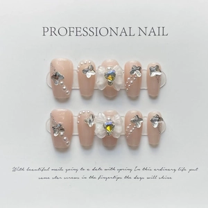 Detalle de uñas postizas ojo de gato rosa con mariposas plateadas y adornos de perla