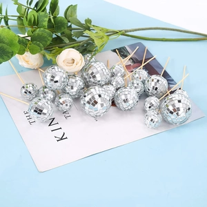 Silver mirror disco ball cake toppers in various sizes with wooden sticks on light blue background