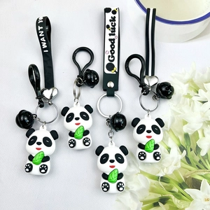 Close-up of cute panda keychains with green leaves, black bells and leather straps