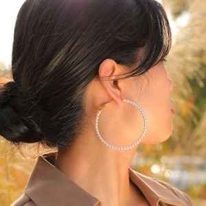 Elegant gold-plated stainless steel hoop earrings with faux pearl embellishments on model
