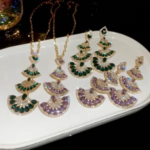 Elegant gold fan-shaped necklace and earrings set with emerald green waterdrop stones