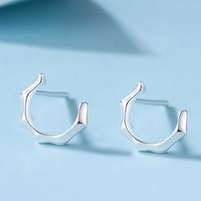 Primo piano di orecchini a lobo minimalisti a forma di elefante cavo in argento S925