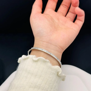 Close-up of a silver titanium steel bangle with sparkling micro-pave crystals on wrist
