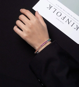 Detail of a silver rainbow bracelet featuring colorful cubic zirconia on a model