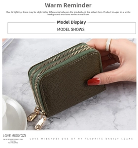 Detalle de la cartera de cuero verde oscuro con textura y dos cremalleras doradas