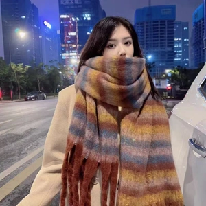Detail of soft rainbow plaid scarf with tassels on model in urban night setting