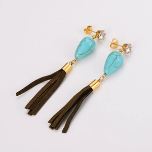 Détail de boucles d'oreilles vintage en or avec gouttes turquoise et franges en daim marron