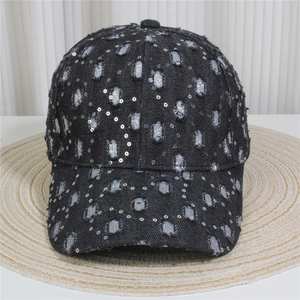 Close-up of black denim baseball cap with silver sequins and distressed torn details