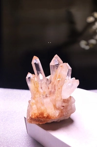 Macro shot of natural white crystal cluster with clear hexagonal quartz prisms on rock base
