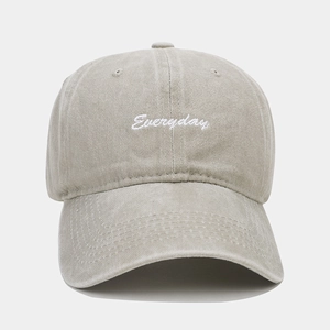 Detail of khaki cotton baseball cap showing white 'Everyday' embroidery and washed fabric
