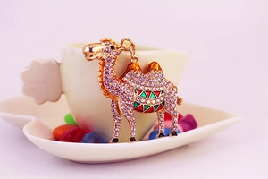 Close-up of golden camel keychain with sparkling rhinestones and colorful enamel details