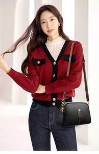 Model wearing minimalist black leather crossbody bag with elegant gold hardware accents