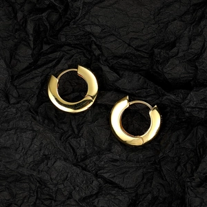 Polished chunky gold hoop earrings set on elegant black textured background