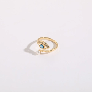 Detail of 14K gold plated evil eye ring with blue enamel, zircons and a pearl accent