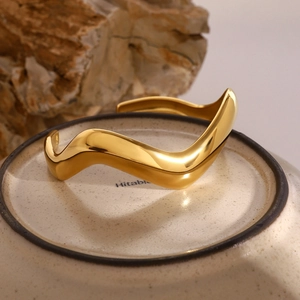 Irregular wavy minimalist 18k gold plated stainless steel cuff bracelet on ceramic tray