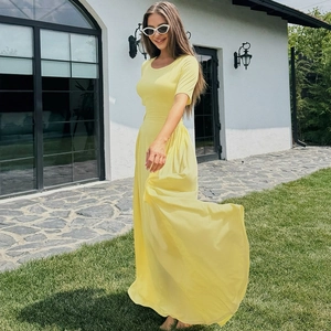 Detail of a bright yellow summer dress showing flowing fabric and slim fit waistline