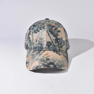 Detail of baseball cap with natural leaf patterns in blue and orange on beige fabric