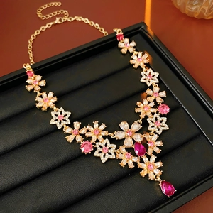 Macro detail of vintage floral necklace with pink rhinestones and a teardrop pendant