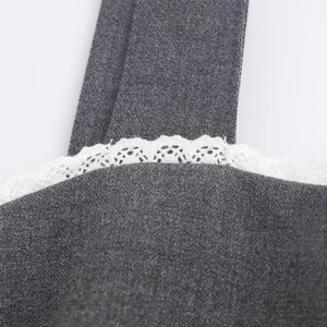 Detail of grey dress straps featuring intricate white lace trim and high-quality fabric