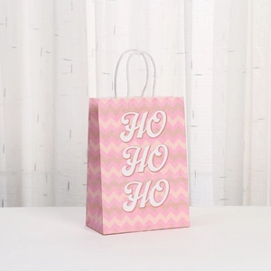 Pink and gold chevron Christmas gift bag with HO HO HO text and white rope handles