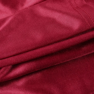 Macro shot of red satin fabric texture showing smooth glossy finish and stitching detail