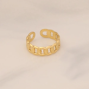 Detailed close-up of golden chain link adjustable ring on marble texture background