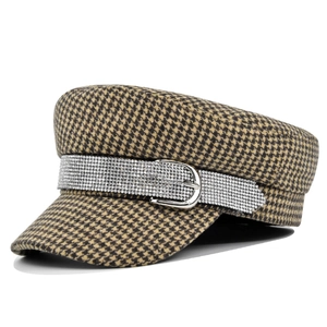 Detail of houndstooth army cap featuring a rhinestone belt buckle and woven texture