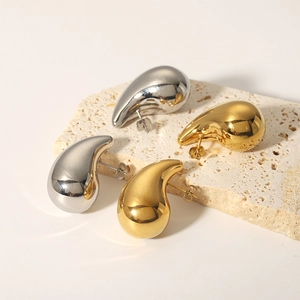 Polished 18k gold and silver plated teardrop earrings on textured stone base