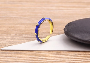 Macro shot of 18K gold-plated ring with deep blue enamel and micro-pave crystals