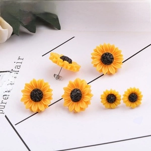 Detailed close-up of sunflower stud earrings in three sizes with vibrant resin petals