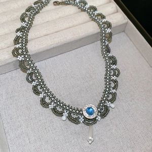 Detailed view of handmade beaded necklace with blue gem and teardrop pearl pendant
