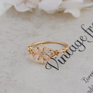 Macro detail of vintage floral ring with opal petals and gold leaf engraving