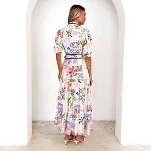 Rückansicht weißes Midi-Kleid mit Blumenmuster, Puffärmeln und Italien-Print vor Architektur