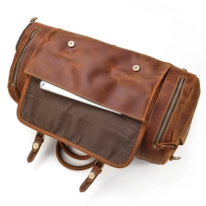 Detail of vintage brown leather travel bag showing interior laptop compartment and textures