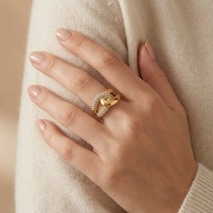 Detailed close-up of a wide gold-plated titanium ring with double pavé crystals on a model