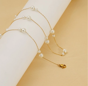 Close-up of 18K gold-plated necklace with alternating sizes of white round pearls